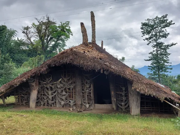 A thatched house with a carved wooden façade